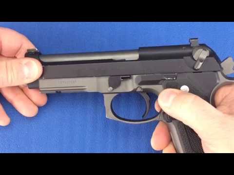 Hands shown beginning to field strip a Beretta 92FS with the slide locked in place.